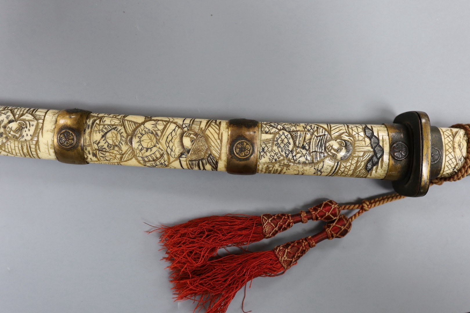 A late 19th century Japanese wakizashi sword, the blade 47.5cm, with sectional stag's horn scabbard and hilt carved with warriors and other figures, gilt metal mounted